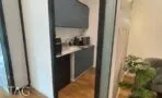מטבחון עם ארונות בגוון כחול כהה, משטח עבודה בהיר וכיור ליד הכניסה למשרד במגדל ספיר