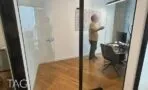 חדרי עבודה סגורים בקירות זכוכית עם פרקט עץ ולוח כתיבה על הקיר במשרד ברמת גן