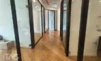 מסדרון ארוך עם פרקט עץ ומחיצות זכוכית משני הצדדים ותאורת פסים בתקרה במשרד בבורסה