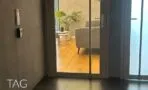 דלת כניסה זכוכית למשרד, ומבעדה פינת המתנה עם ספה אפורה, צמח ופרקט עץ ברמת גן