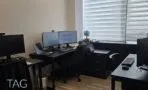 חדר עבודה עם שולחנות שחורים, ארון מגירות וחלון רחב עם וילון זברה, משרד להשכרה במגדלי אלון תל אביב