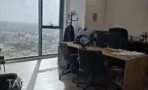 חדר מנהל עם שולחן עץ, כיסאות משרדיים וחלון מהרצפה עד התקרה עם נוף פתוח לתל אביב, מגדלי אלון