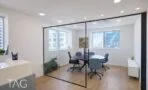 חדר ישיבות בקירות זכוכית עם שולחן עגול וכיסאות כחולים במשרד להשכרה במגדל משה אביב רמת גן
