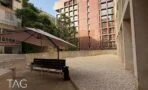 חצר פנימית מרוצפת חצץ עם ספסל ושמשייה בבית ו.א באזור רוטשילד