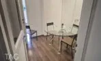 חדר ישיבות עם שולחן זכוכית עגול וכיסאות מתכת ועץ
