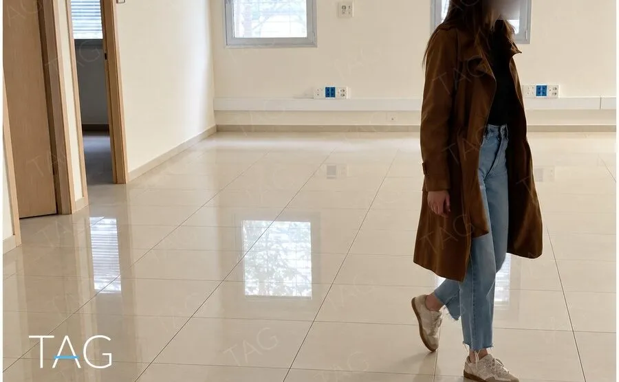 חלל משרדים מואר עם ריצוף פורצלן בגוון שמנת וחלונות לעצים