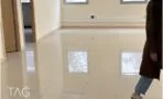 מרחב עבודה פתוח עם אריחים גדולים מבריקים ודלתות עץ לחדרים צדדיים