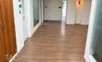 מסדרון משרדים עם פרקט, ארון עץ בנוי וקירות זכוכית מחלבית