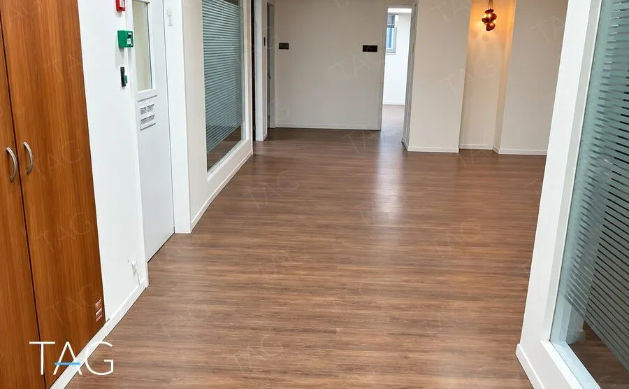 מסדרון משרדים עם פרקט, ארון עץ בנוי וקירות זכוכית מחלבית