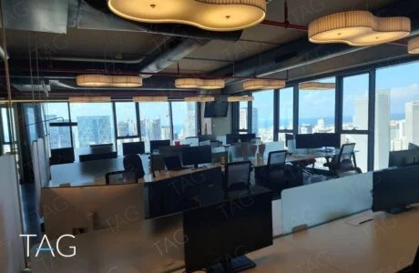 אופן ספייס עם שורות עמדות עבודה, תאורה תלויה מבד וחלונות לנוף העיר והים במגדלי אלון בתל אביב