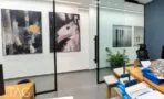 חדר עבודה עם מחיצת זכוכית במסגרת שחורה ותמונות אמנות על הקיר, משרד להשכרה במגדל סקיי טאוור