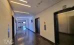 מבואת מעליות עם רצפת שיש כהה וקירות אבן בהירה במגדל רוטשילד 22