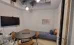 חדר ישיבות קטן עם שולחן אובלי, ספסל מרופד ומסך על הקיר במשרד בתל אביב