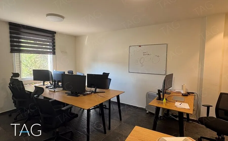 חדר צוות עם שולחנות עבודה, מסכים, לוח מחיק ותאורת תקרה עגולה, משרד להשכרה ברחוב הוברמן