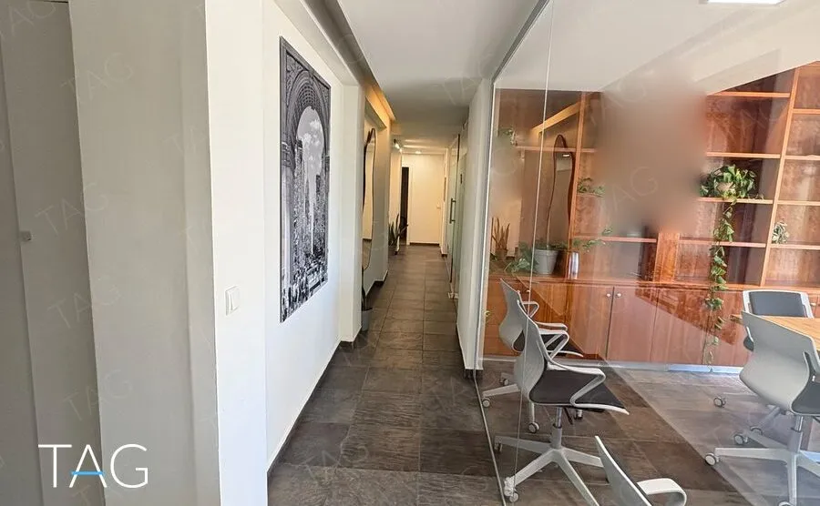 מסדרון עם ריצוף אבן כהה וקיר זכוכית לחדר הישיבות, משרד להשכרה ברחוב הוברמן בתל אביב